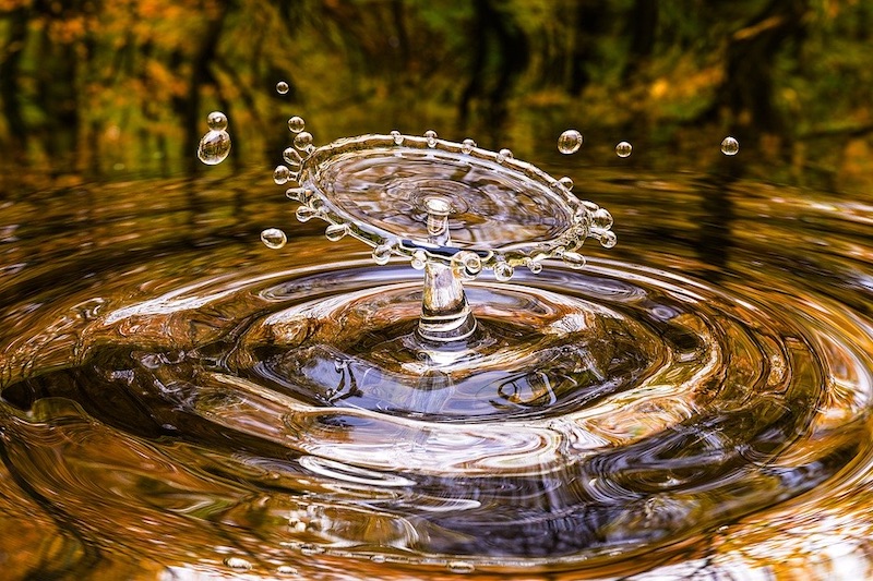 Foto van een waterdruppel die in een plas valt