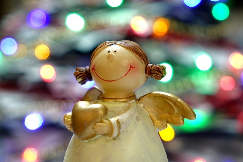 Foto van een kerstengeltje met lichtjes op de achtergrond