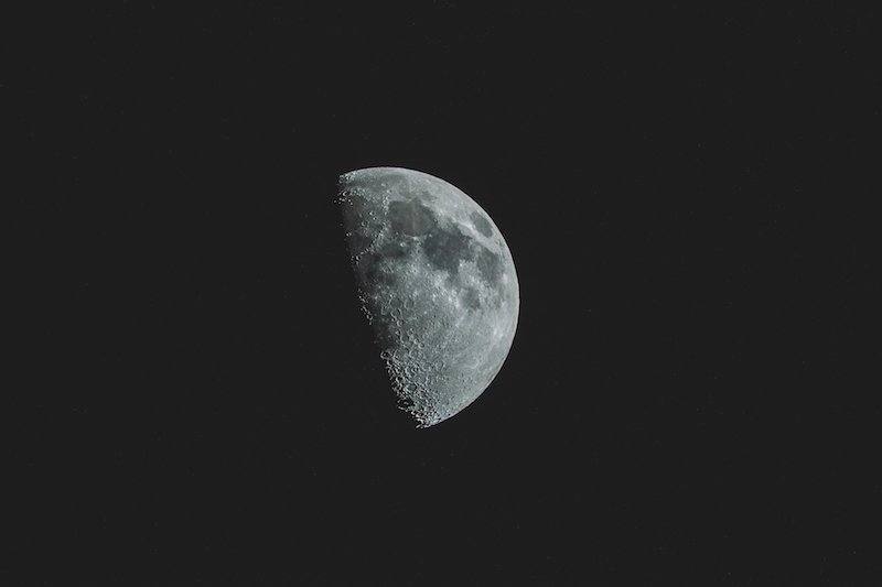 Foto van zwarte hemel met een halfvolle maan 