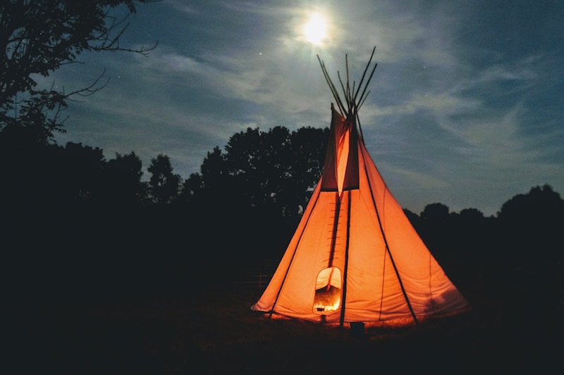 Foto van verlichte tipi in de nacht